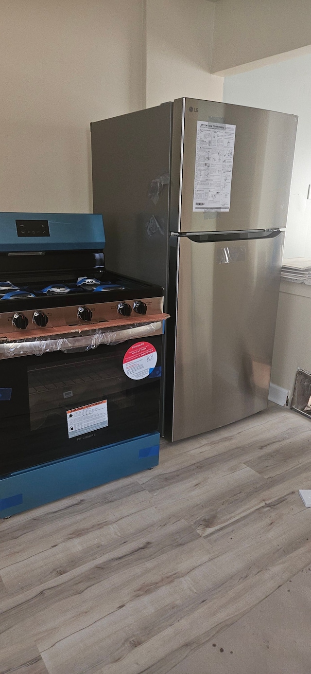 kitchen featuring stainless steel appliances and light hardwood / wood-style floors