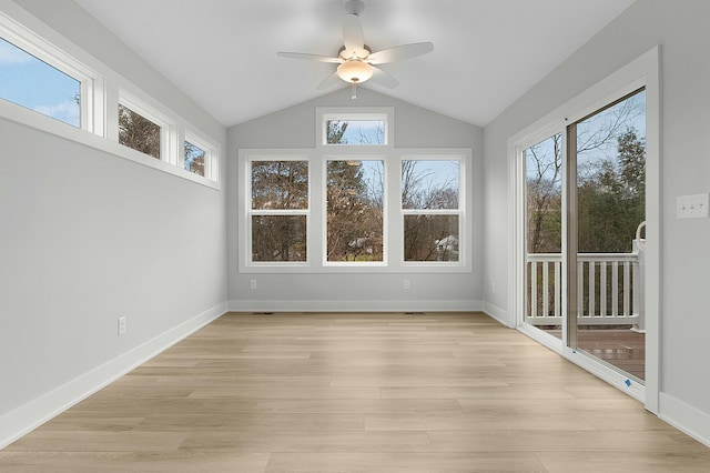 unfurnished sunroom featuring ceiling fan, a healthy amount of sunlight, and vaulted ceiling