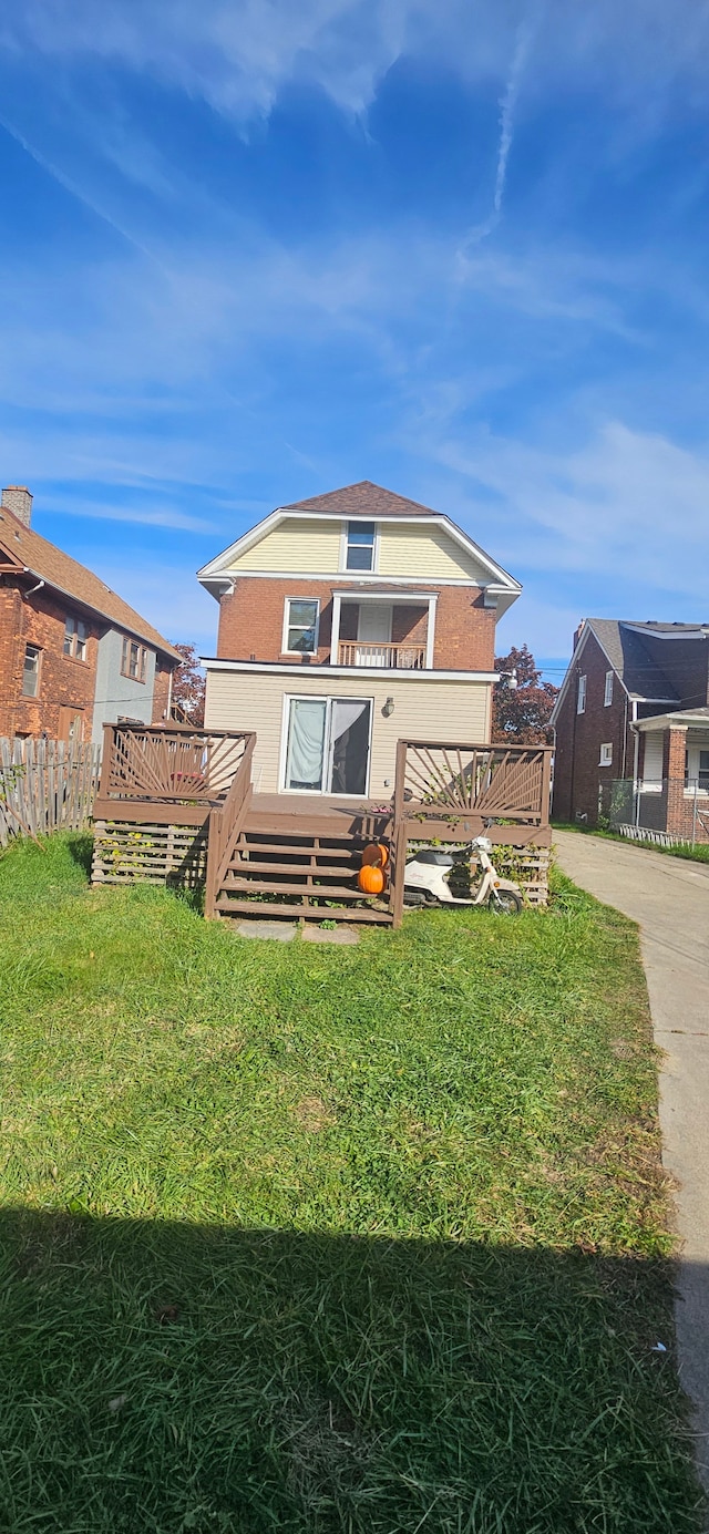 rear view of property featuring a yard and a deck