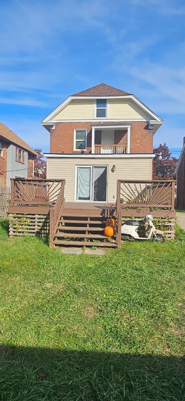 rear view of property featuring a deck and a yard