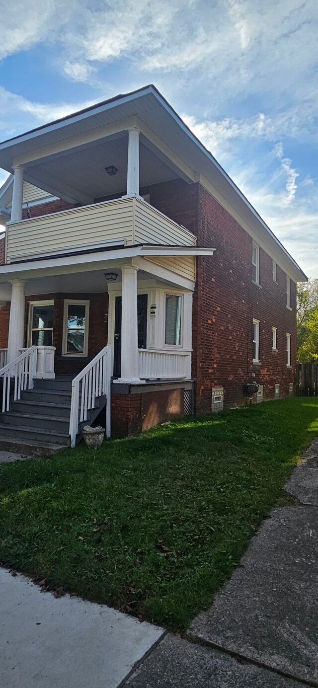 view of front of house with covered porch and a front lawn