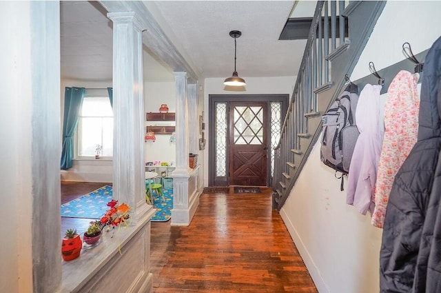 interior space with dark hardwood / wood-style flooring, decorative columns, and plenty of natural light