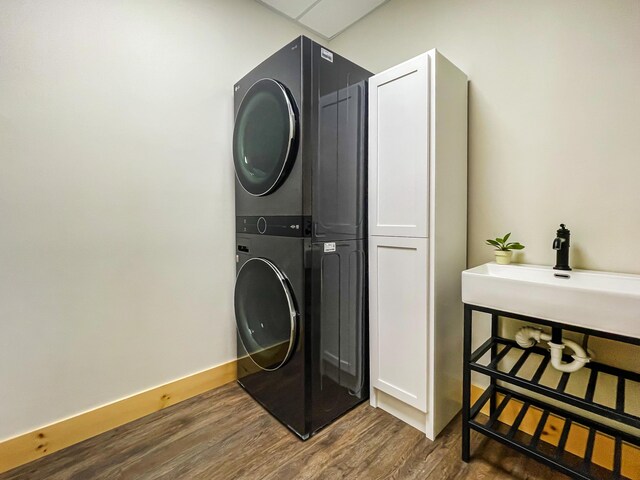 620 S Main St, Wayland, MI 49348 - laundry room with stacked washer / drying machine, wood finished floors, and cabinet space