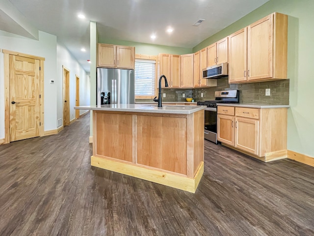 kitchen featuring light brown cabinetry, dark hardwood / wood-style flooring, stainless steel appliances, and a kitchen island with sink