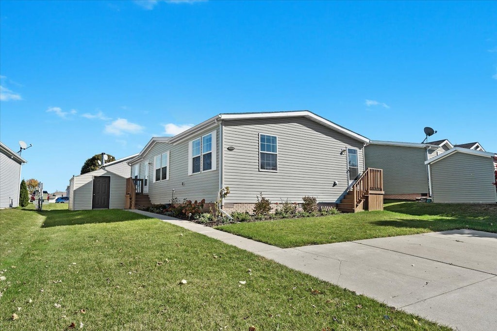 view of side of property with a yard and a storage unit