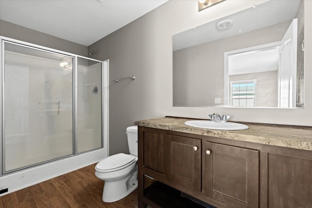 bathroom featuring walk in shower, toilet, vanity, and hardwood / wood-style flooring