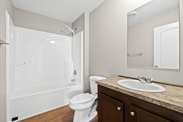 full bathroom featuring shower / bathing tub combination, wood-type flooring, vanity, and toilet