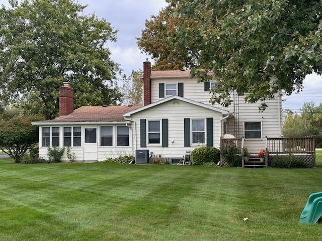 back of house featuring central AC, a deck, and a lawn