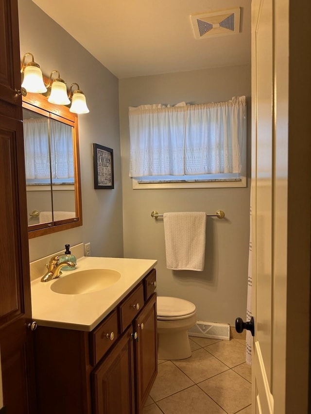 bathroom featuring tile patterned flooring, vanity, and toilet