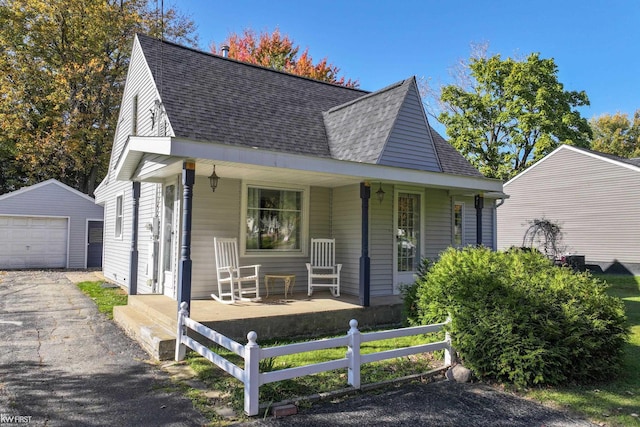 view of front of home featuring a porch, a garage, and an outdoor structure