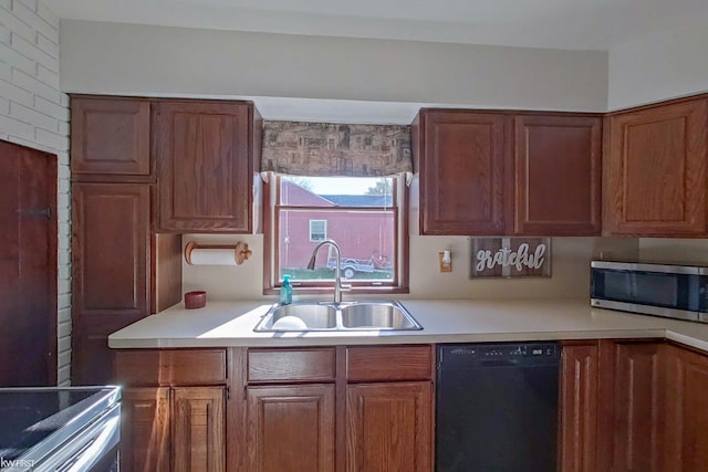 kitchen featuring brick wall, sink, and appliances with stainless steel finishes