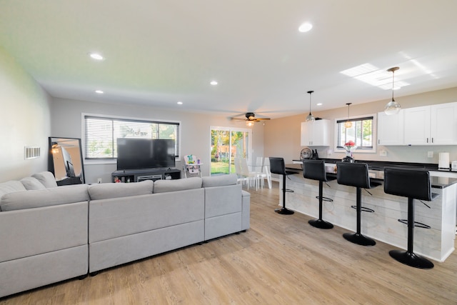 living room featuring ceiling fan, a healthy amount of sunlight, and light hardwood / wood-style flooring