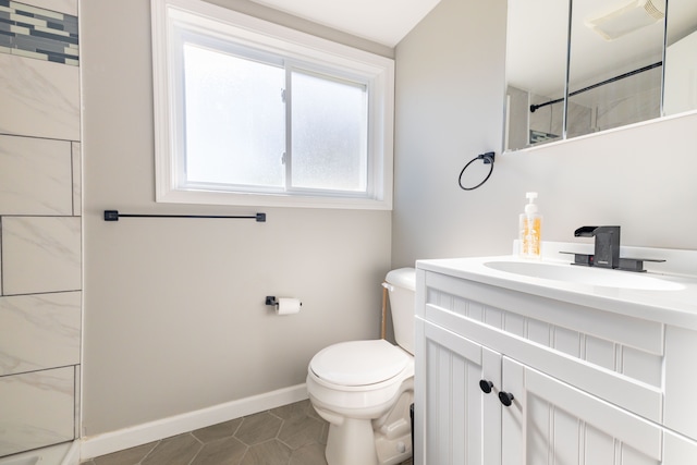 bathroom with toilet, a tile shower, vanity, and tile patterned floors