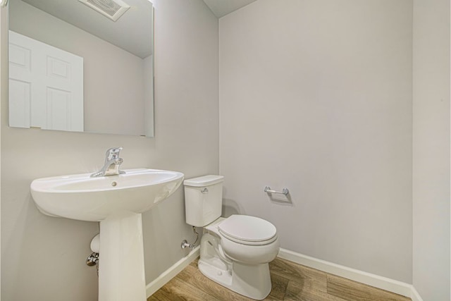 bathroom with wood-type flooring and toilet