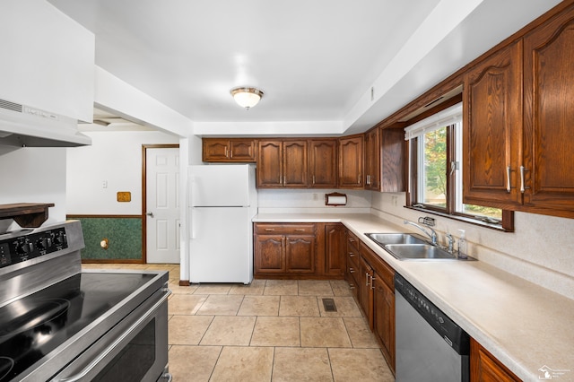 kitchen featuring sink, light tile patterned floors, stainless steel appliances, and exhaust hood