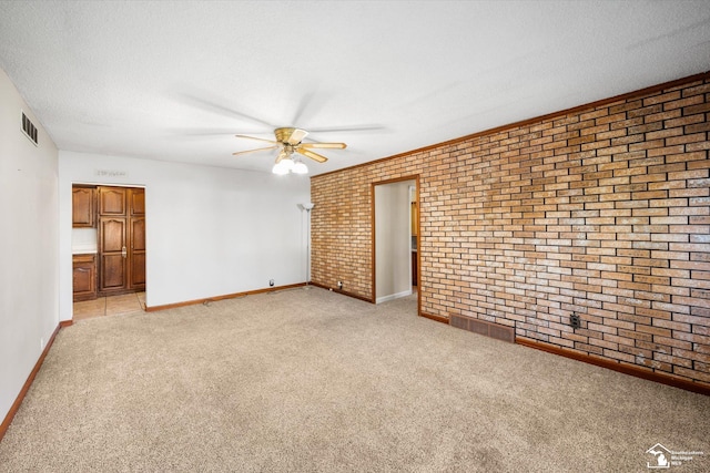 carpeted empty room featuring ceiling fan, brick wall, and a textured ceiling