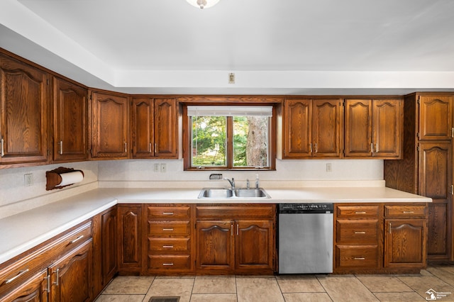 kitchen with stainless steel dishwasher, light tile patterned flooring, and sink