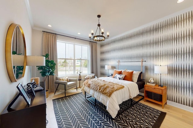 bedroom featuring an inviting chandelier, ornamental molding, and light hardwood / wood-style flooring