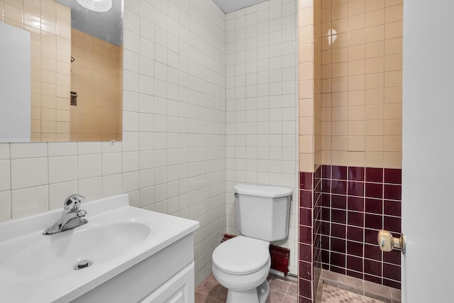 bathroom with tile patterned flooring, vanity, tile walls, and toilet