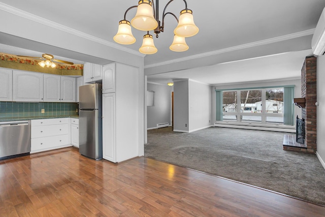 kitchen featuring pendant lighting, dark carpet, white cabinets, tasteful backsplash, and stainless steel appliances