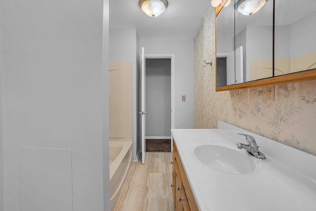 bathroom with hardwood / wood-style floors, vanity, and a bathing tub