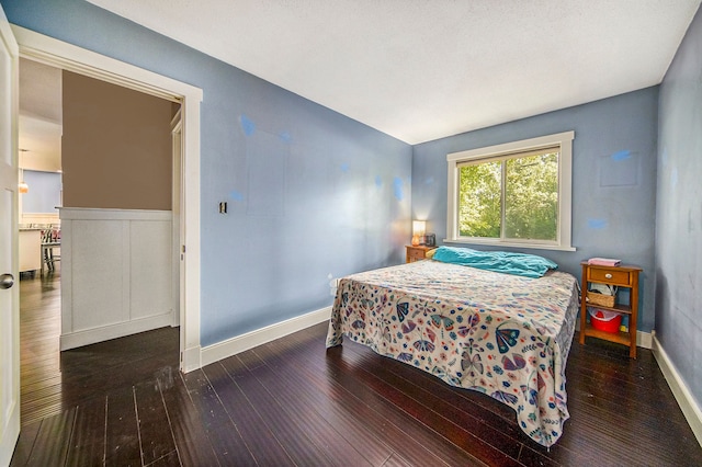 bedroom with dark hardwood / wood-style floors