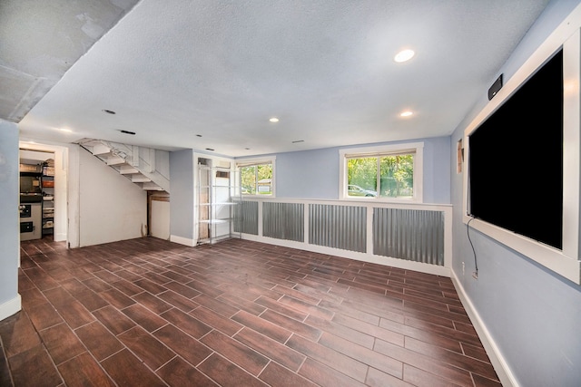 empty room featuring a textured ceiling and dark hardwood / wood-style floors