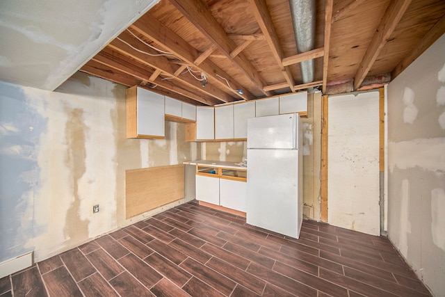 basement featuring white fridge and dark hardwood / wood-style floors