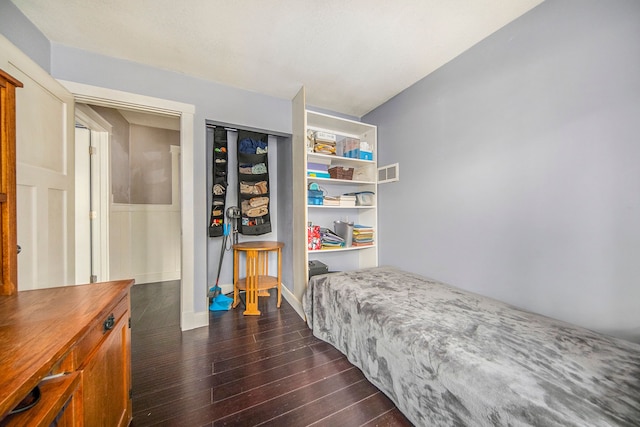 bedroom with dark hardwood / wood-style floors and a closet