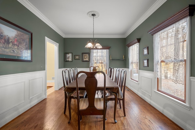 dining area with crown molding, light hardwood / wood-style flooring, and a healthy amount of sunlight