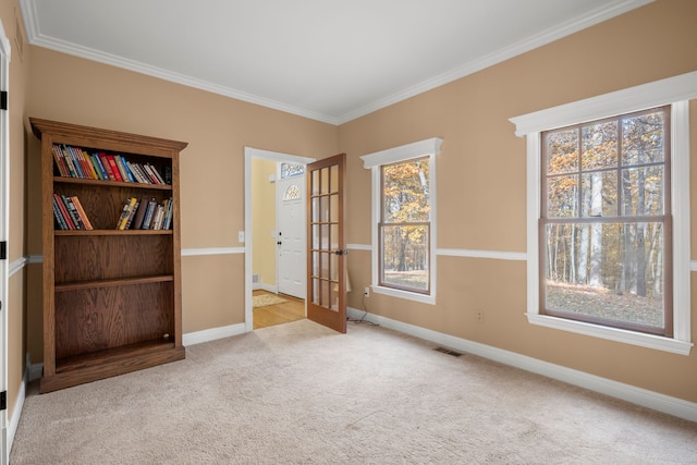 carpeted empty room with crown molding and french doors