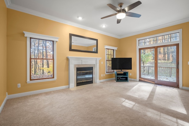 unfurnished living room with crown molding, ceiling fan, and light colored carpet