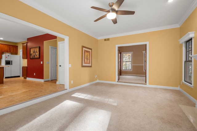 unfurnished living room featuring light colored carpet, ceiling fan, and crown molding