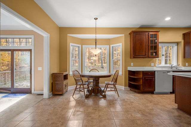 kitchen featuring a wealth of natural light, hanging light fixtures, stainless steel dishwasher, and sink