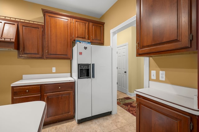 kitchen featuring white fridge with ice dispenser and light tile patterned flooring