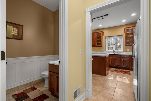 bathroom featuring tile patterned floors, vanity, toilet, and track lighting