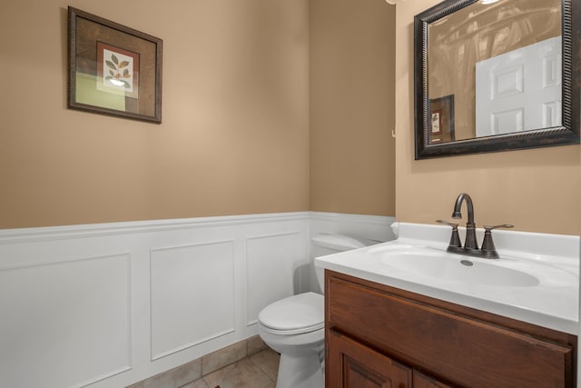 bathroom with tile patterned flooring, vanity, and toilet