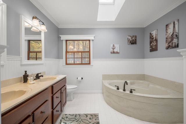 bathroom with vanity, a skylight, toilet, ornamental molding, and a tub to relax in