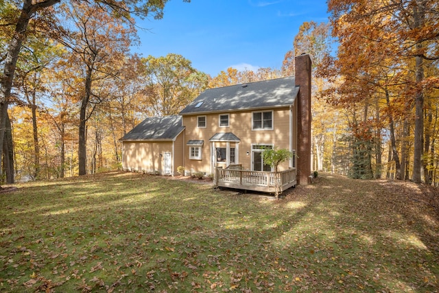 back of property featuring a wooden deck and a yard