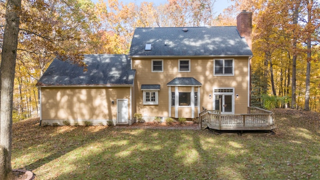 rear view of house with a yard and a wooden deck