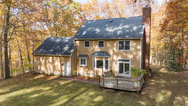 back of property featuring a lawn and a wooden deck