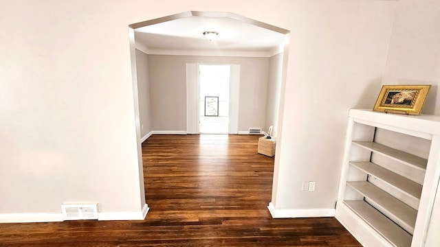 corridor featuring dark wood-type flooring and ornamental molding