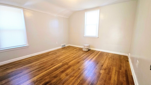 bonus room with hardwood / wood-style floors and vaulted ceiling