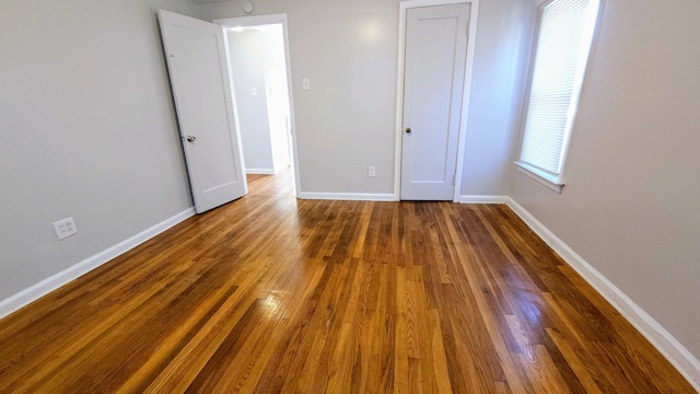 unfurnished bedroom with dark wood-type flooring