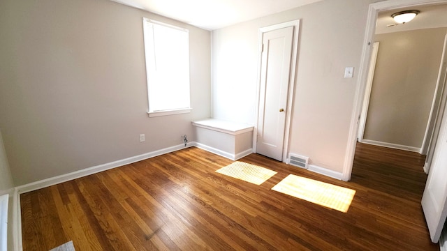 unfurnished bedroom with a closet and dark hardwood / wood-style flooring