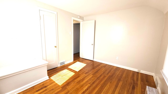 unfurnished bedroom featuring a closet and dark wood-type flooring