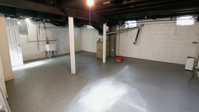 basement featuring sink, heating unit, and a wealth of natural light