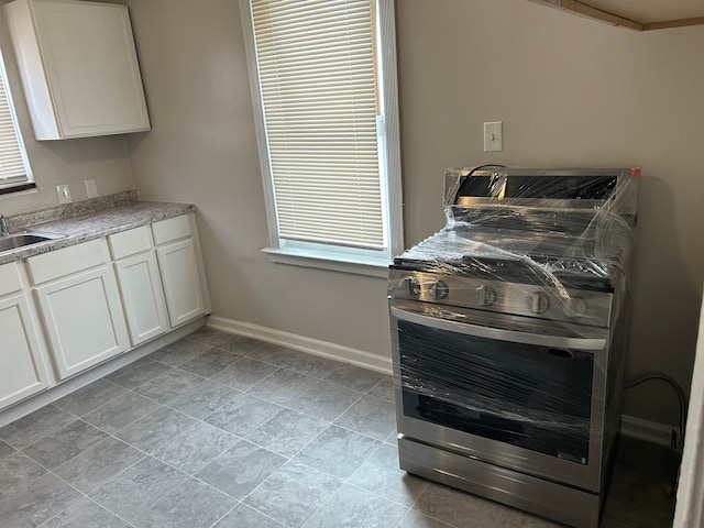 kitchen with sink, white cabinets, and ornamental molding