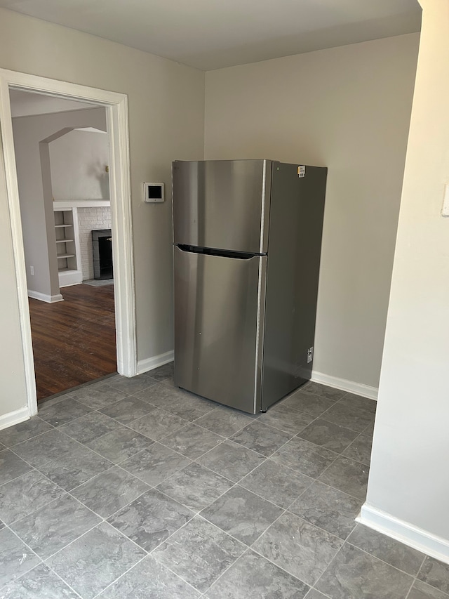 kitchen featuring built in shelves and stainless steel refrigerator