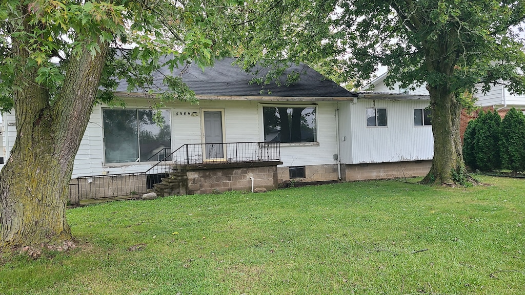 rear view of house featuring a yard